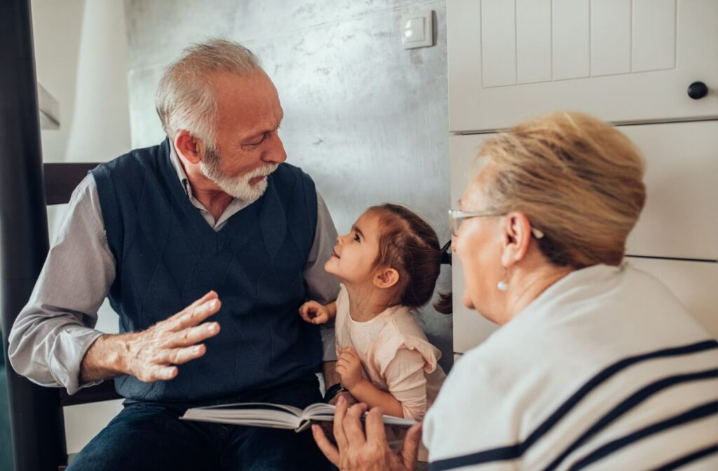 Two seniors utilize a photo album to tell stories about their youth to a young grandchild