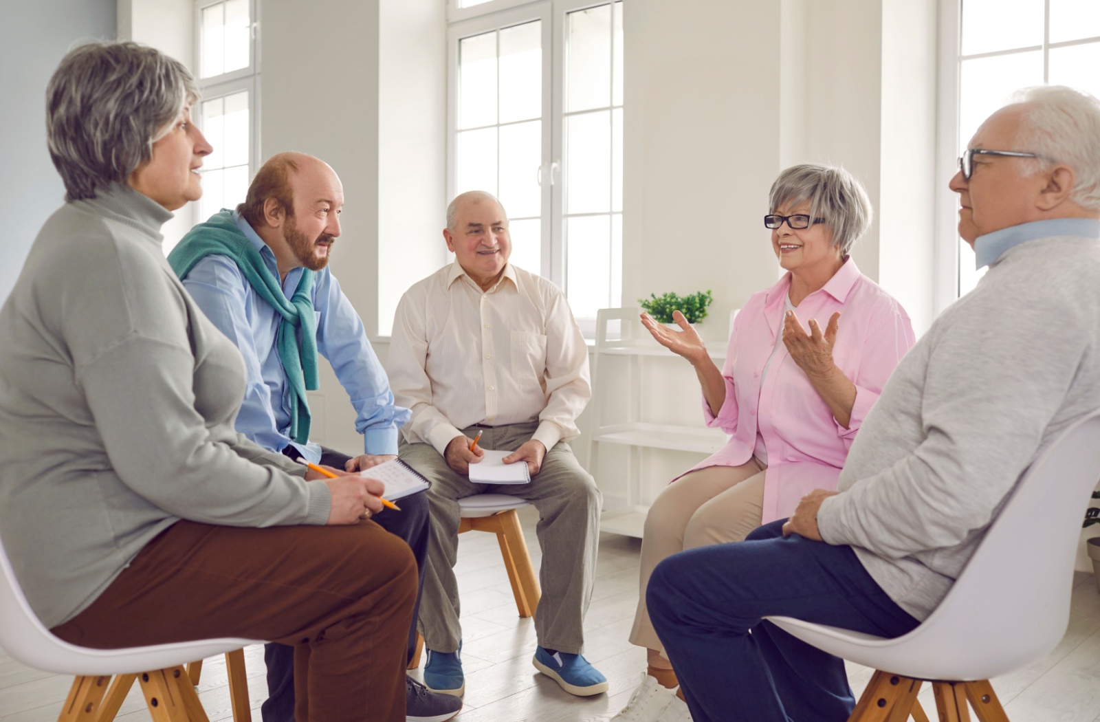 A group of older adults in a circle engaging in memory recall games.