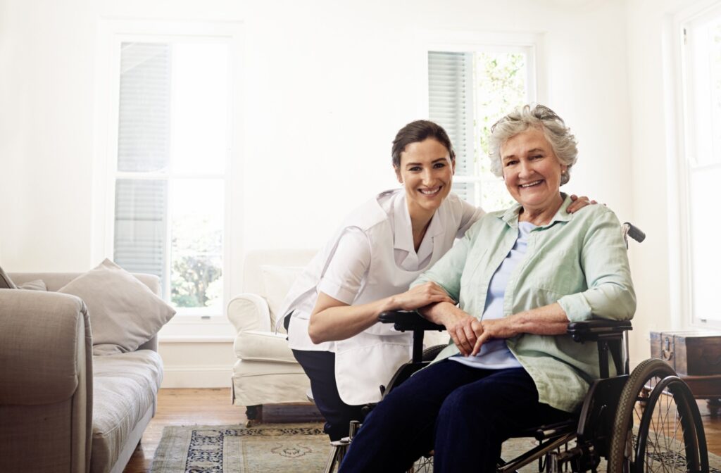 A smiling nurse and an assisted living resident pose for the camera together.